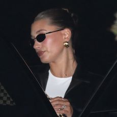 hailey bieber exits a car wearing her oval diamond engagement ring