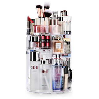 A fully stocked rotating acrylic makeup and skincare organizer with adjustable shelving