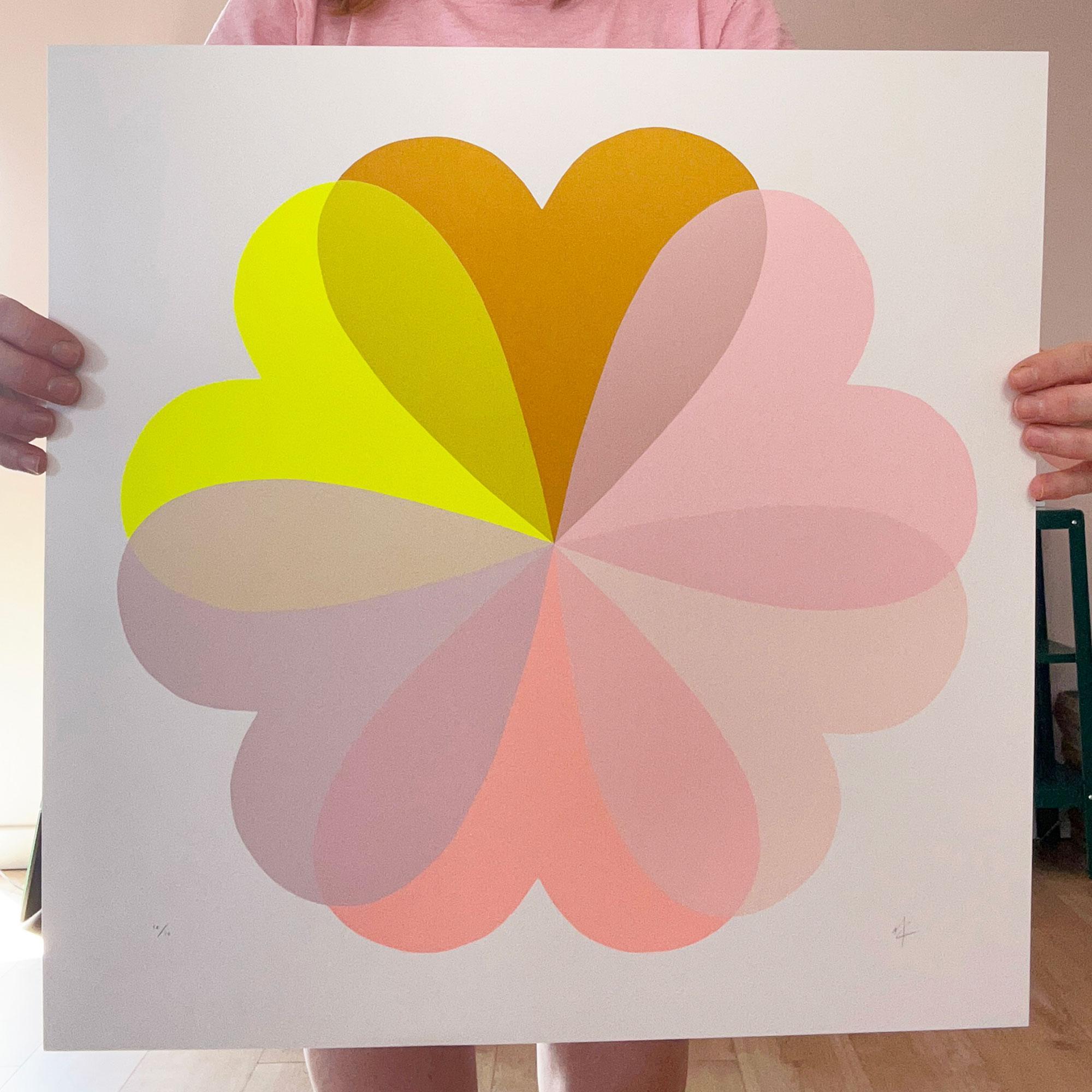 Pink and yellow graphic artwork of flower shape made up of hearts