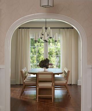 dining room with arched doorway and white upholstered chairs
