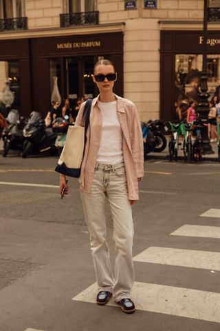 woman wearing a button-down, t-shirt, and jeans