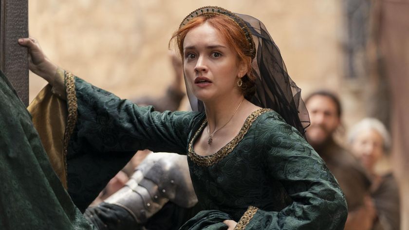 Alicent grabs hold of a wall in the street