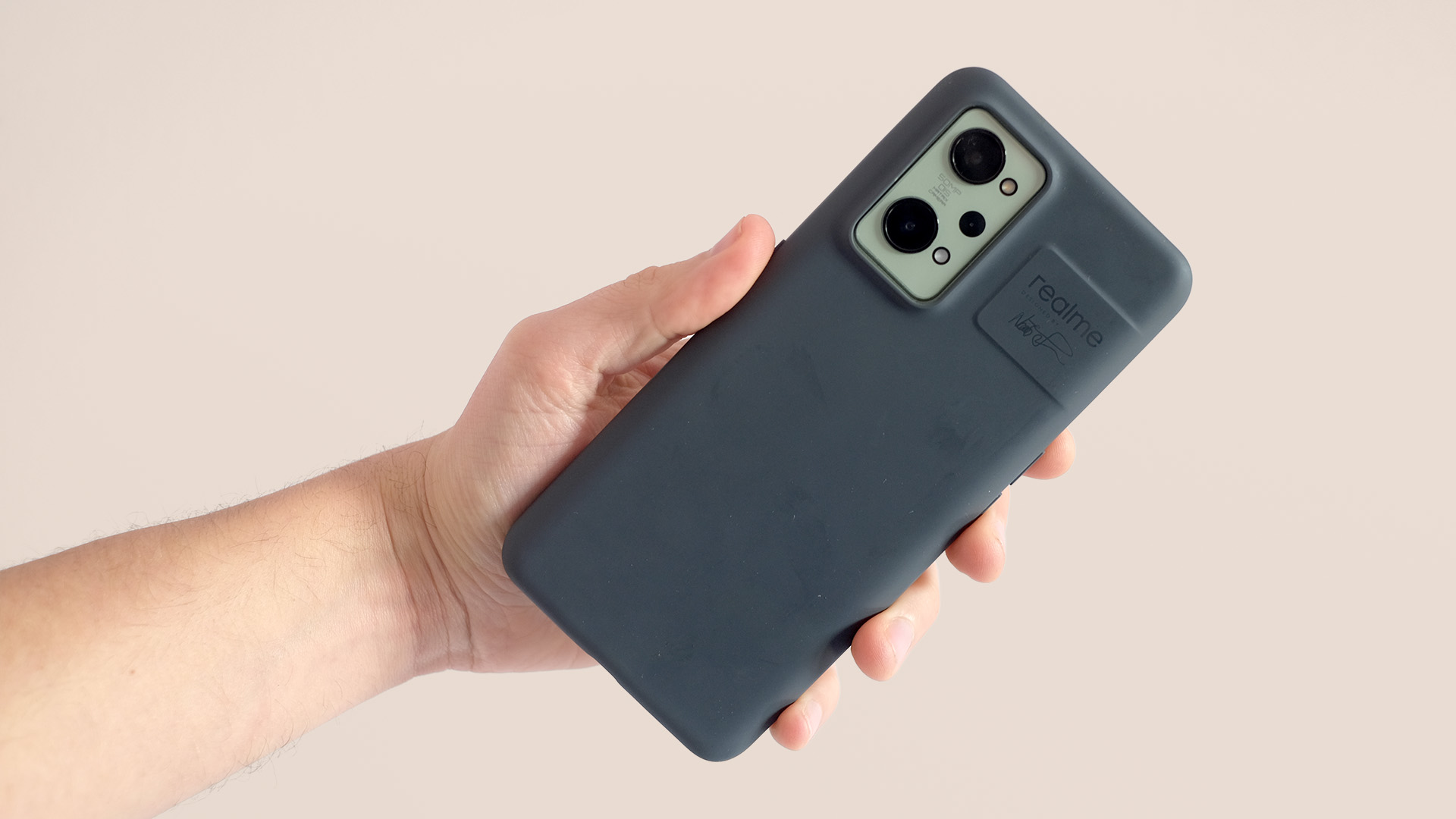 A Realme GT 2 in a case, held in someone's hand