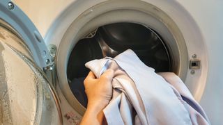 Putting shirt into the washing machine