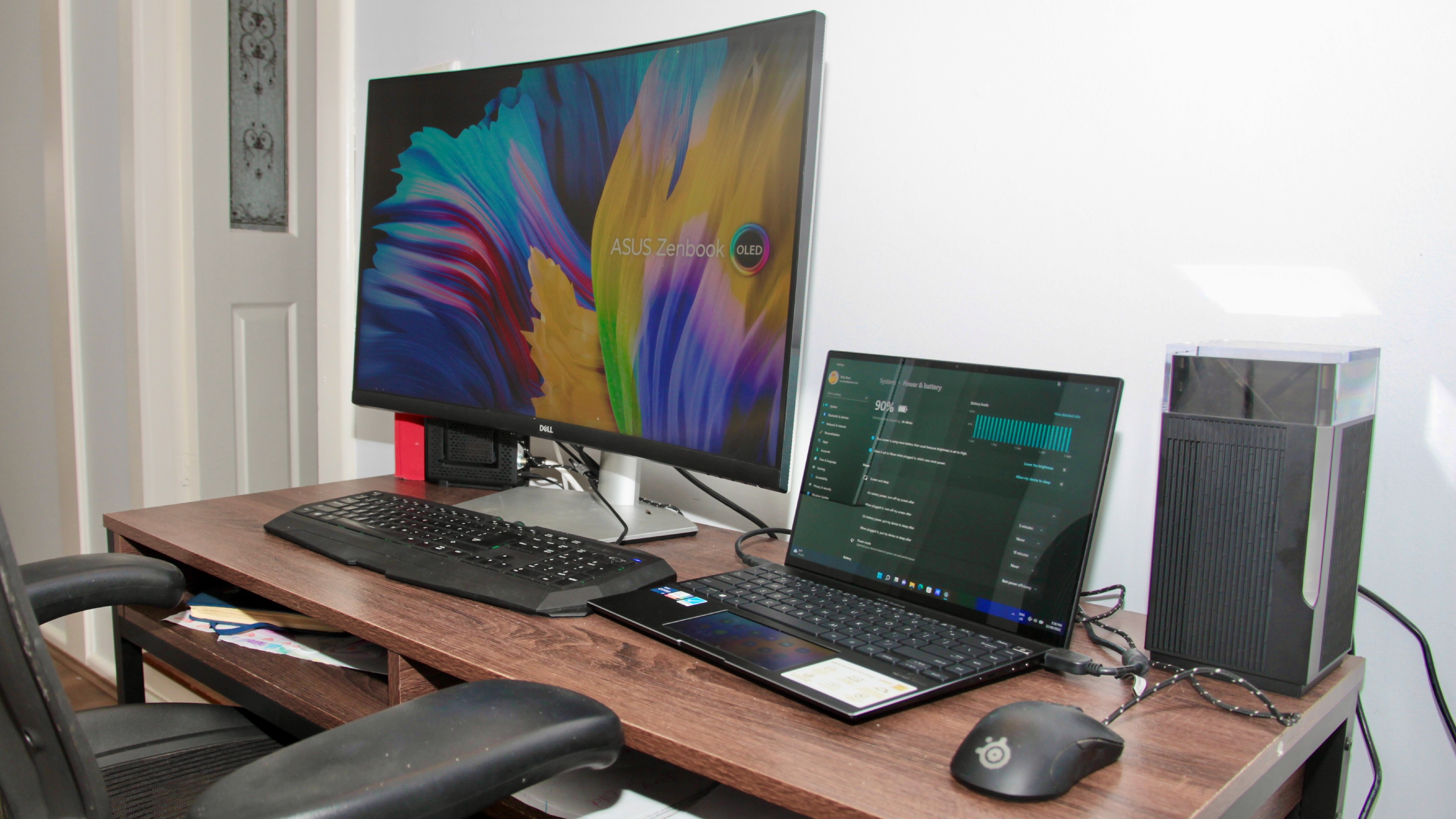 The Asus ZenWiFi Pro XT12 mesh router set up beside a computer