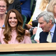 Kate Middleton wears a pink shirt dress and has long brown wavy hair attending Wimbledon with her dad Michael Middleton