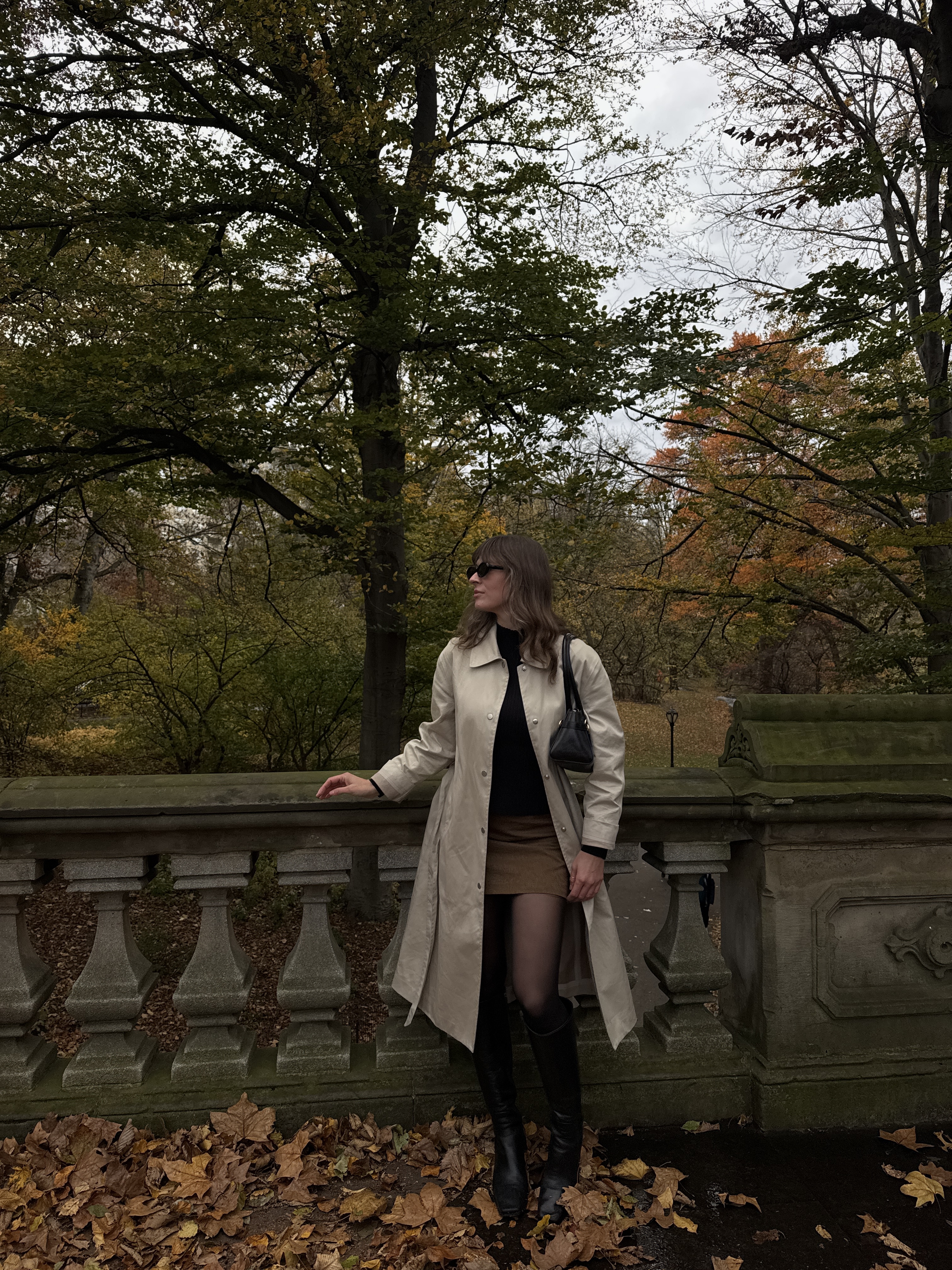 Kathryn Zahorak in new york wearing trench coat, sunglasses, brown skirt, and knee high boots