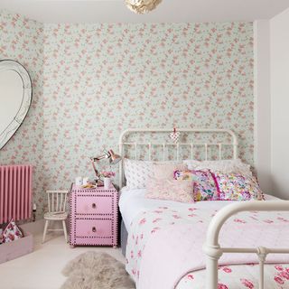 pink floral printed wall and white bed in bedroom