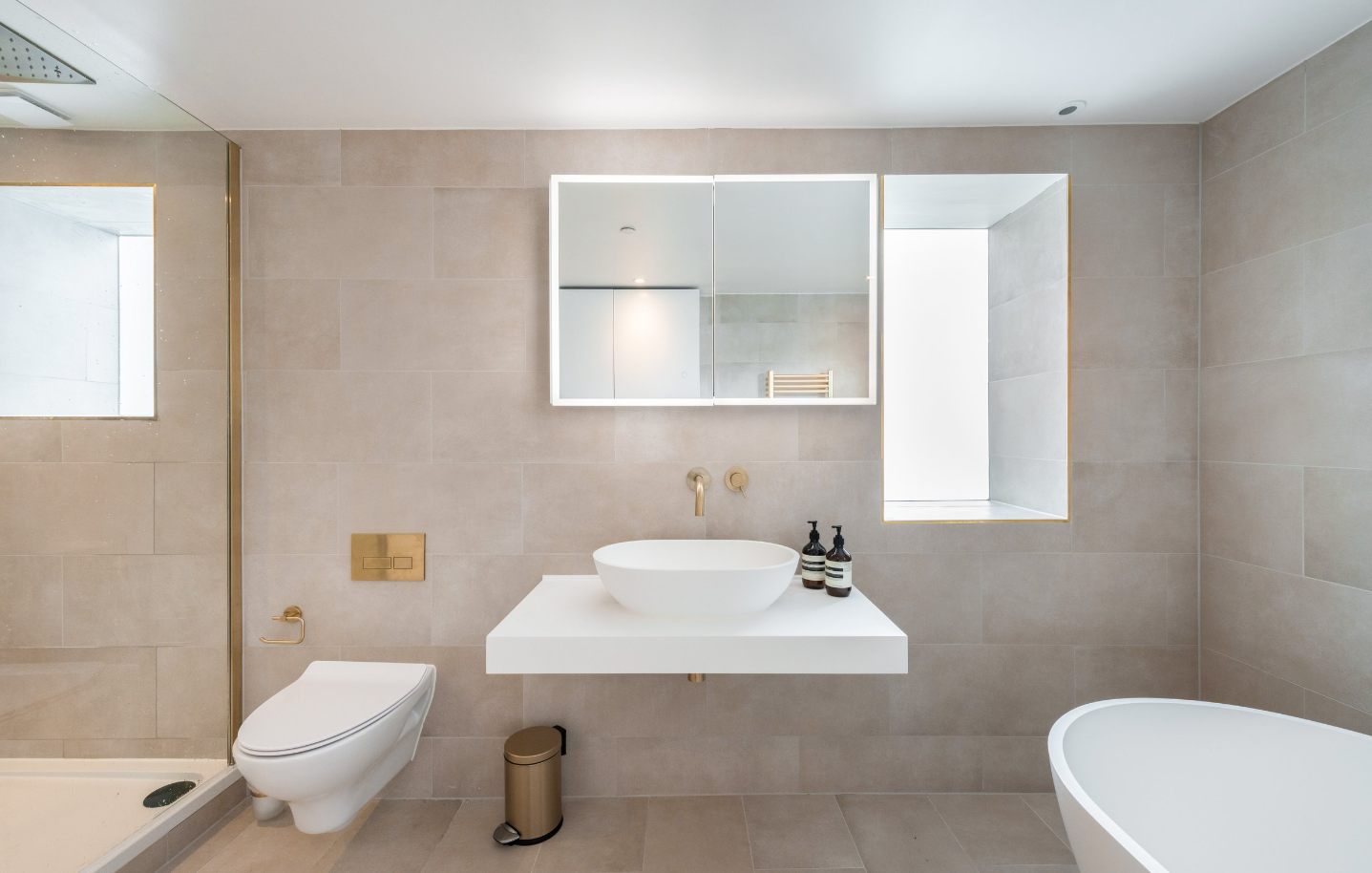 a bathroom with the floor and walls all decked on in large beige brown tiles