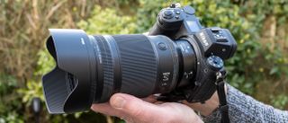 Nikon Z 35mm f/1.2 S product shot with lens held in hand