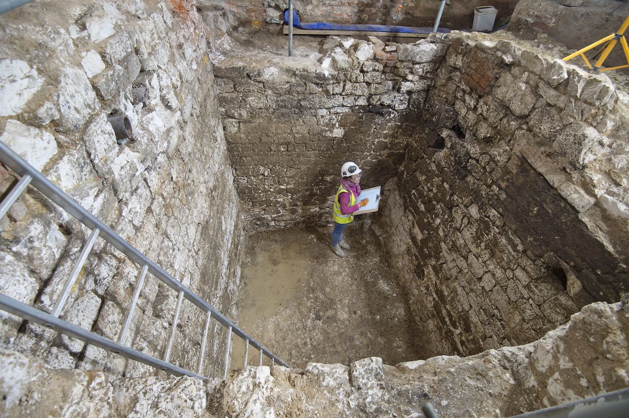 A MOLA archaeologist examines the cesspit uncovered in the basement of the Courtauld Institute of Art.