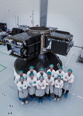 Astranis engineers pose with four MicroGEO communications satellites.