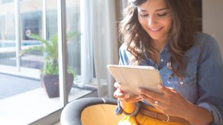 Woman using tablet with sunbeams and lens flare