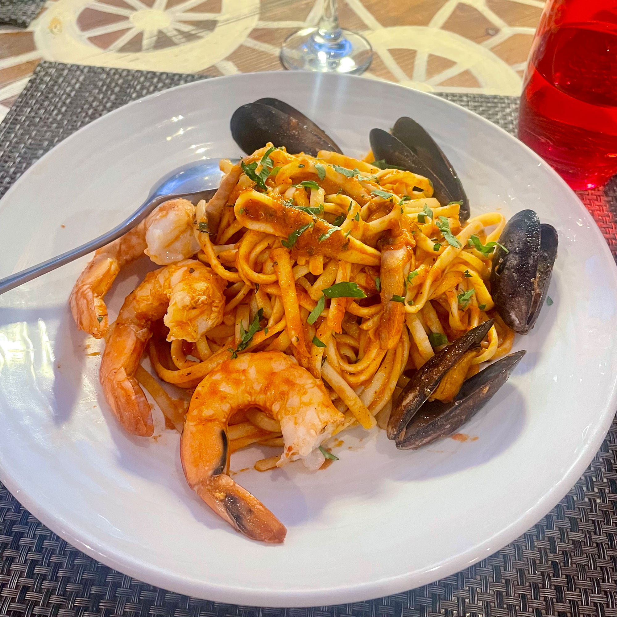 White bowl of seafood pasta with prawns and mussels
