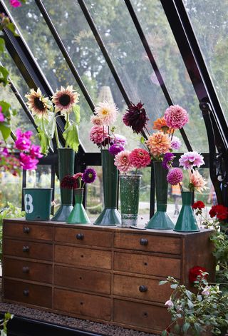 Dahlias displayed in vintage florist vases