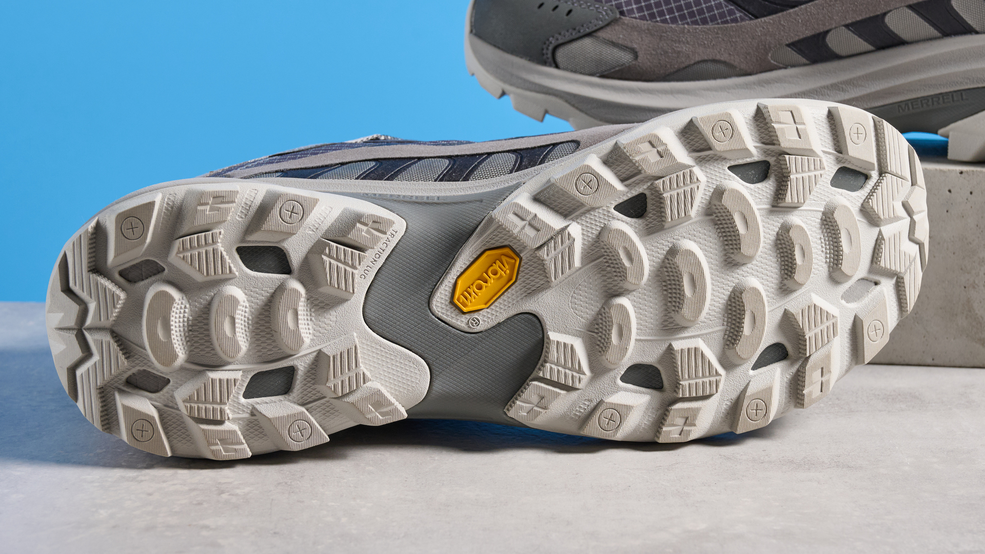 A photo of the Merrell Moab Speed 2 boots against a blue background