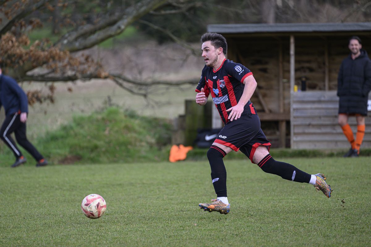Some footballers playing in a field