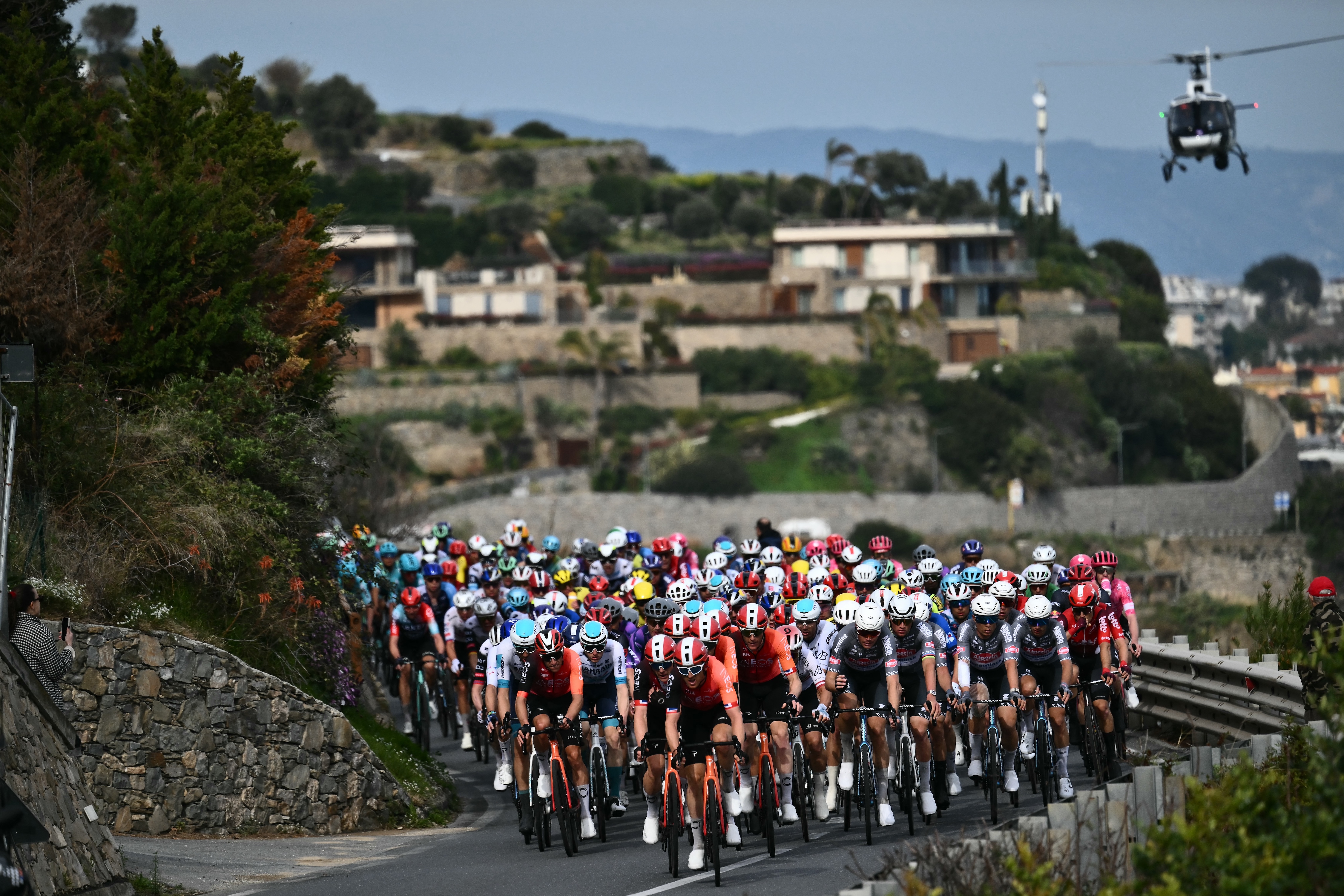 Team Ineos' British rider Geraint Thomas leads the pack along the sea during the Milan - Sanremo one-day classic cycling race, on March 22, 2025. (Photo by Marco BERTORELLO / AFP)