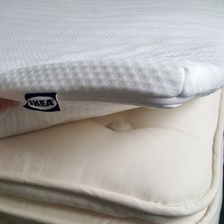 The IKEA NISSEHOLM mattress topper being tested over a mattress