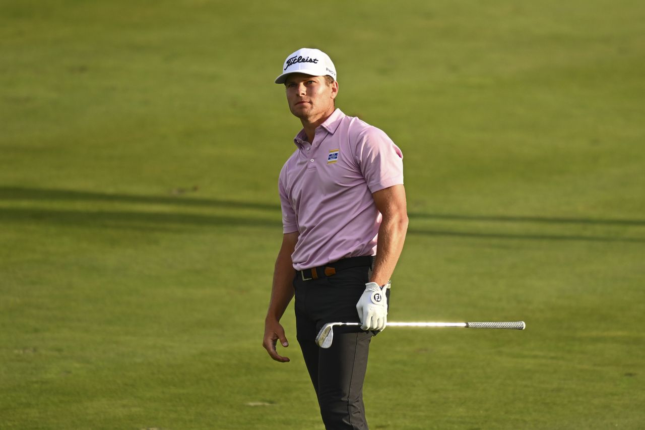 Michael Brennan hits a wedge shot and watches it in the air