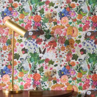 a white wallpaper covered in close together bold flowers with bunnies hiding behind them. very bold