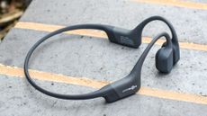 Shokz OpenRun headphones on top of a wall