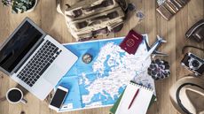 laptop, map, notepad and other travel-related items