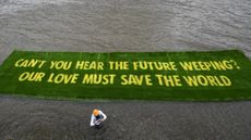 A giant banner grown on a carpet of living grass tells governments to ‘act now’ in the lead-up to COP26, on 25 June 2021