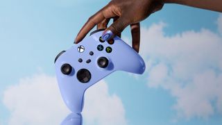 A hand holding an Xbox controller