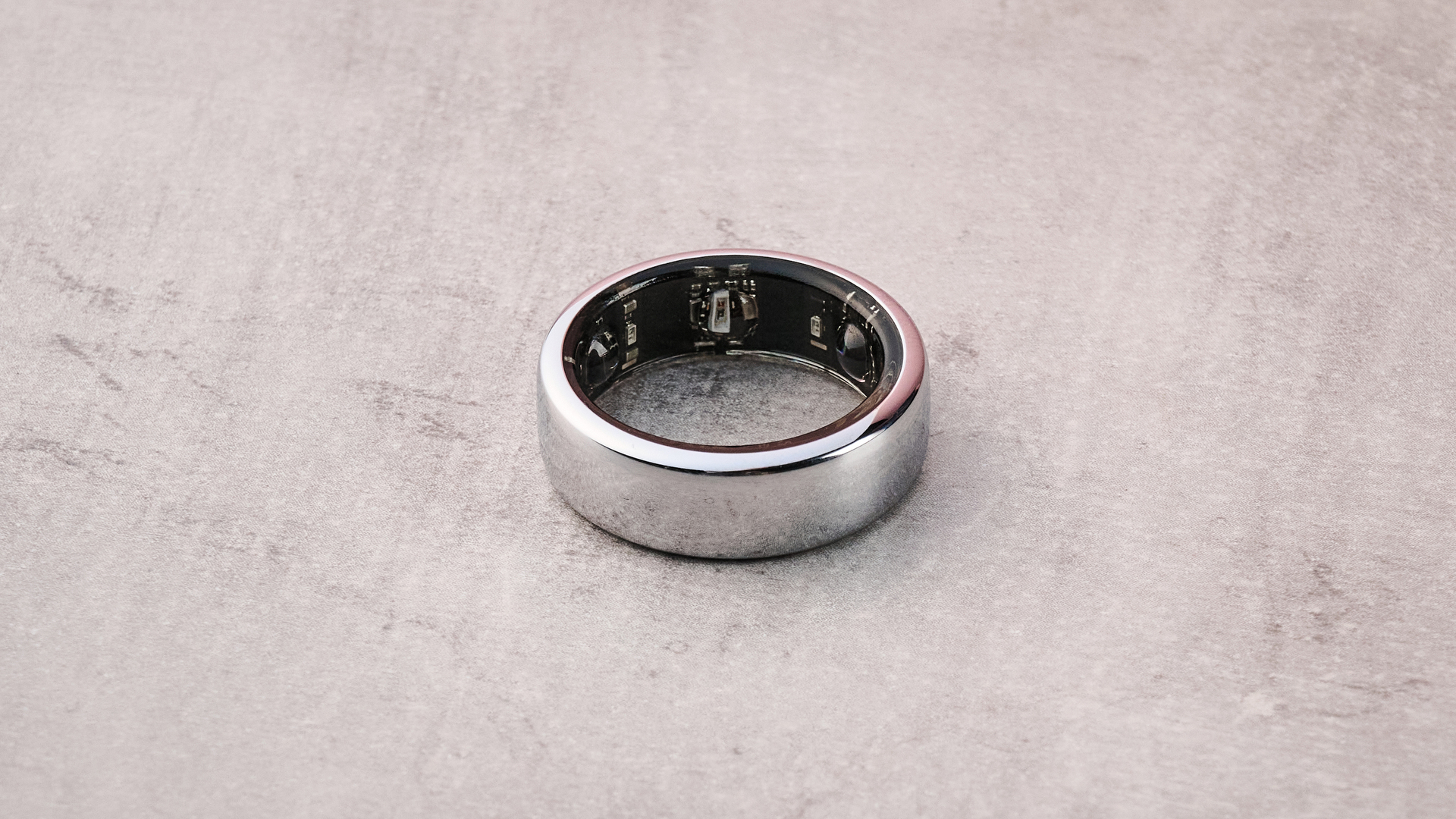 The Oura Ring 3 flat on a table, showing the internal sensors.