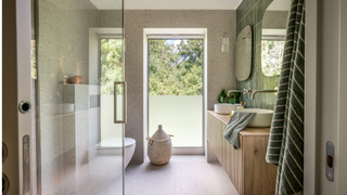 Bathroom with a large window overlooking trees by the toilet