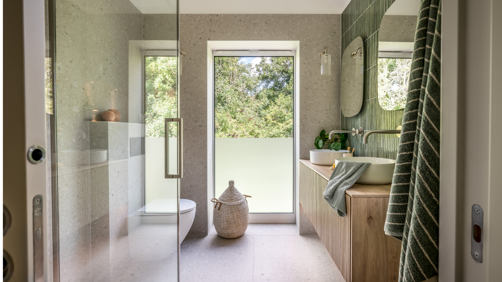 Bathroom with a large window overlooking trees by the toilet