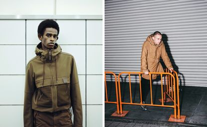 Left: Male model wearing khaki hooded jacket and trousers, against a white tiled wall. Right: Male model wearing a long brown jacket and black trousers, leaning forward onto an orange metal guard rail, stone paved floor and metal shutter backdrop