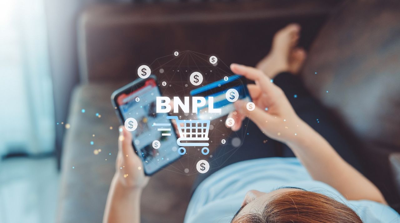 Woman holding credit card and word &quot;BNPL&quot; and dollar signs overlay.using smartphone to shop , with 