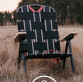 foldable black chair in a field of grass