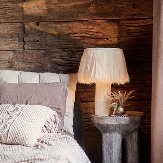 bedroom with wooden feature wall and fluffy lamp