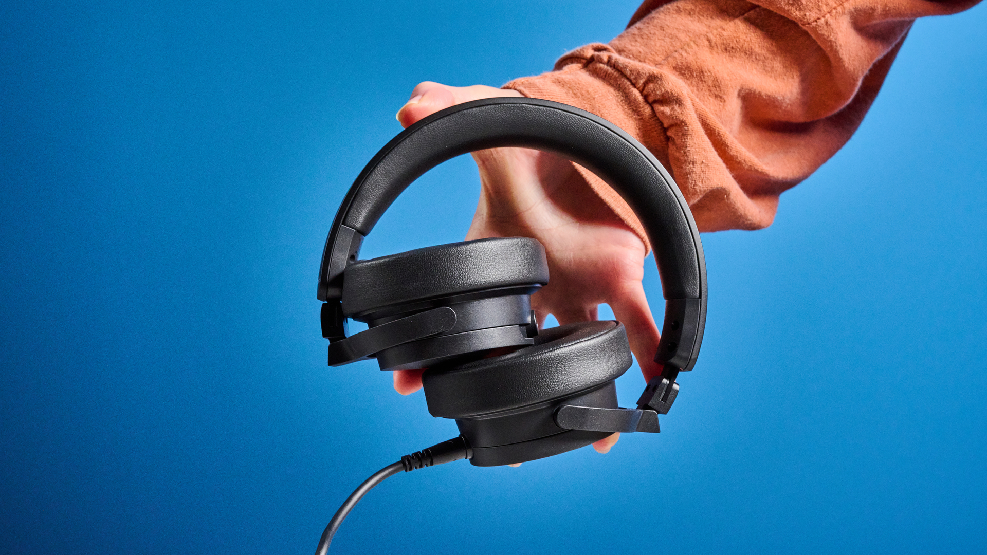 the beyerdynamic DJ 300 Pro X headphones in black showing their ear cups, carry bag, and connectivity options photographed against the blue tom's guide background