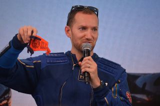 Virgin Galactic lead operations engineer Colin Bennett holds up the University of Illinois pennant that he carried into space for his alma mater on board the Unity 22 mission, July 11, 2021.