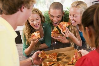A group of friends share a pizza
