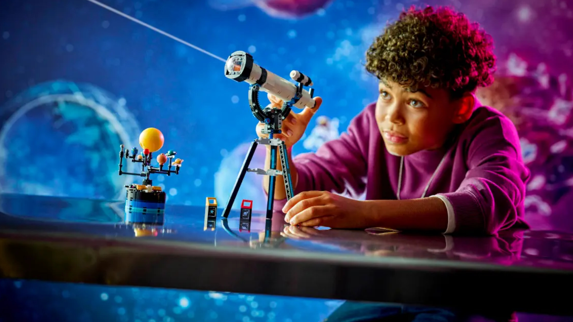 A child aims a Lego telescope against a cosmic background