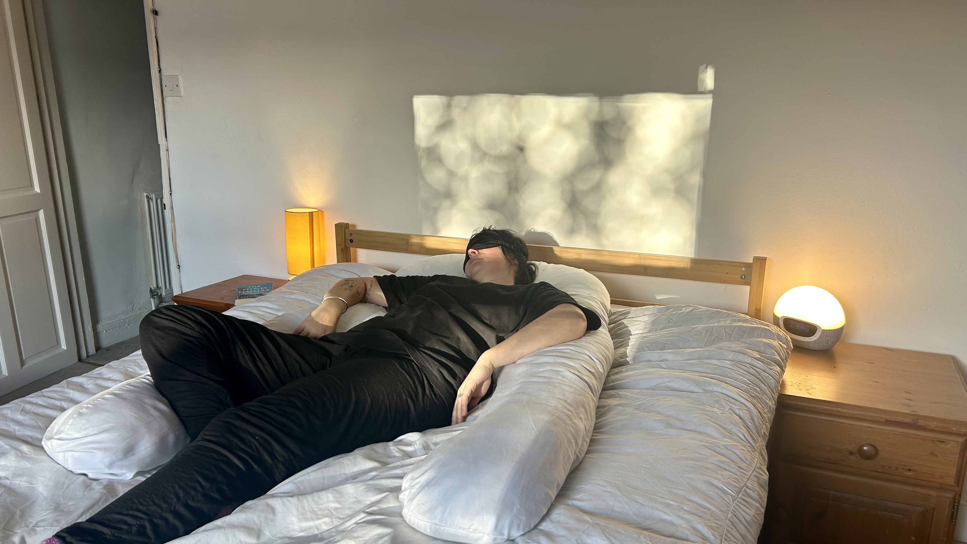 Tom&#039;s Guide Sleep Features Editor lying on her back using the Yana 360&amp;deg; Body Pillow.