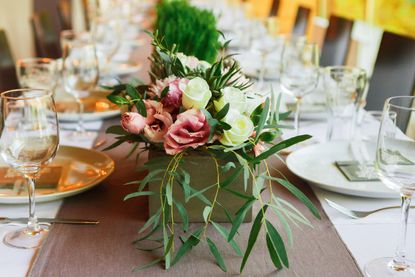 Flower Bouquet And Plants On A Plated Dinner Table