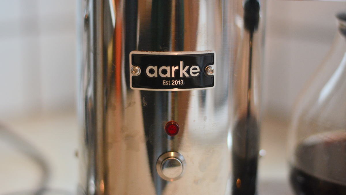 Image of the Aarke Coffee System &ndash; a stainless steel coffee bean grinder and drip coffee maker &ndash; positioned on a kitchen counter