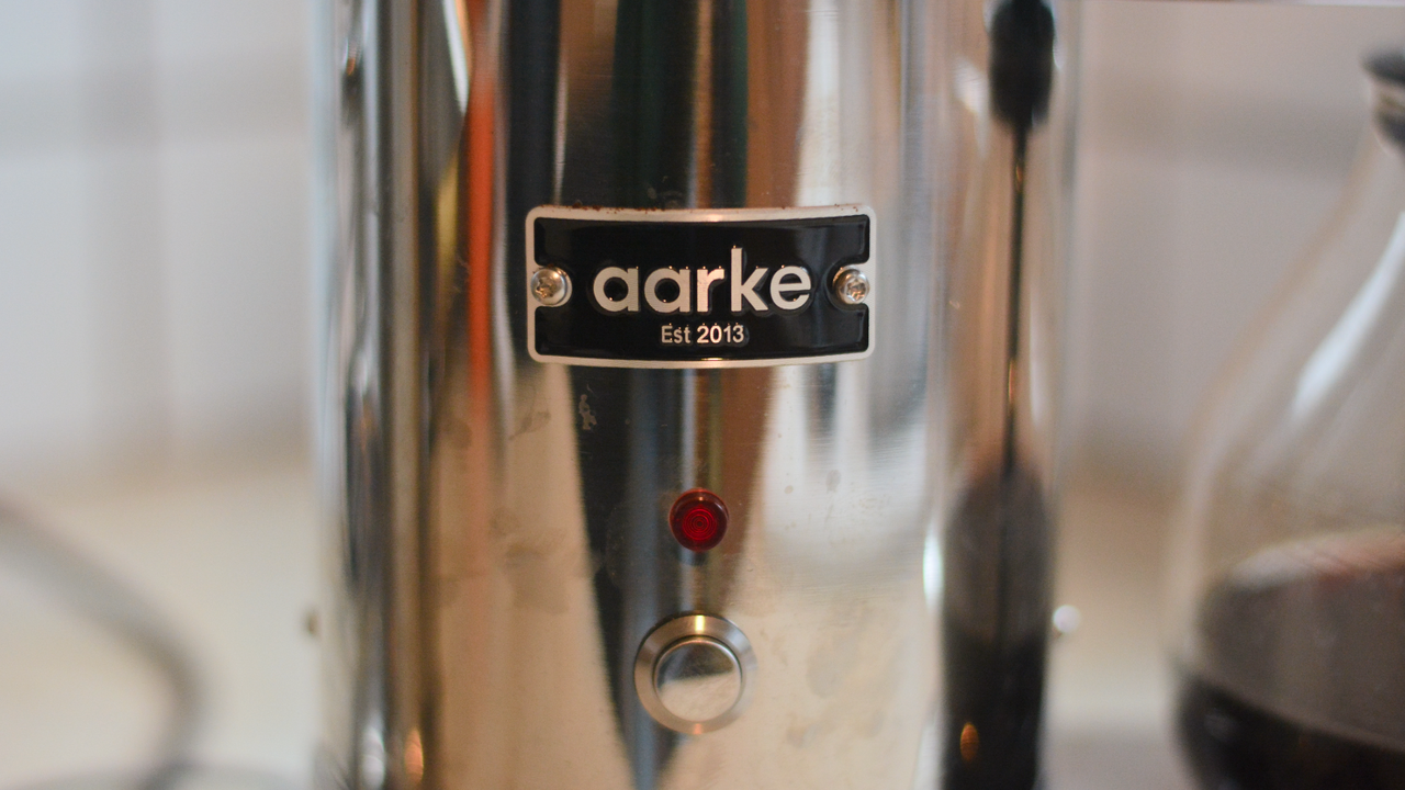 Image of the Aarke Coffee System &ndash; a stainless steel coffee bean grinder and drip coffee maker &ndash; positioned on a kitchen counter