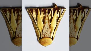 An ancient Egyptian lotus pendant with inlaid stones, dating to about 1350 B.C. Most of the objects found in the tombs, including this one, are from the time of Queen Nefertiti, who wore similar jewelry. 