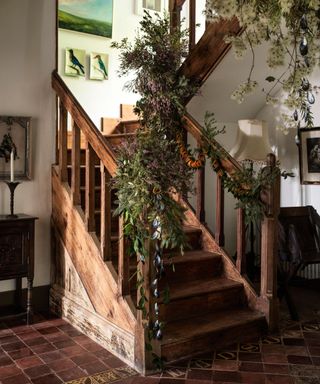Wooden traditional staircase decorated with a foliage garland