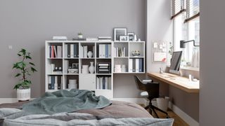 A bedroom with a shelving unit and a floating desk