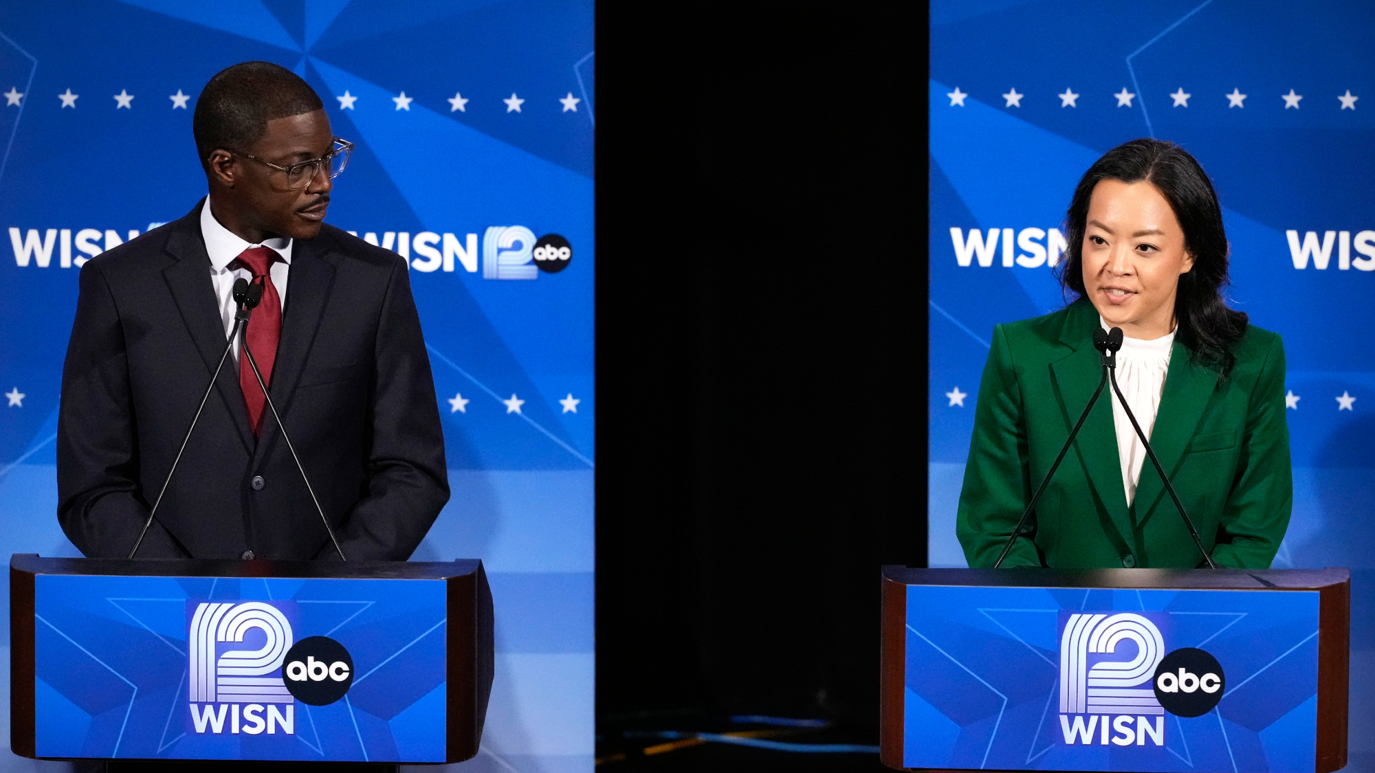 Democratic gubernatorial candidate Francesca Hong, right, talks as David Crowley listens during a primary debate in Milwaukee.