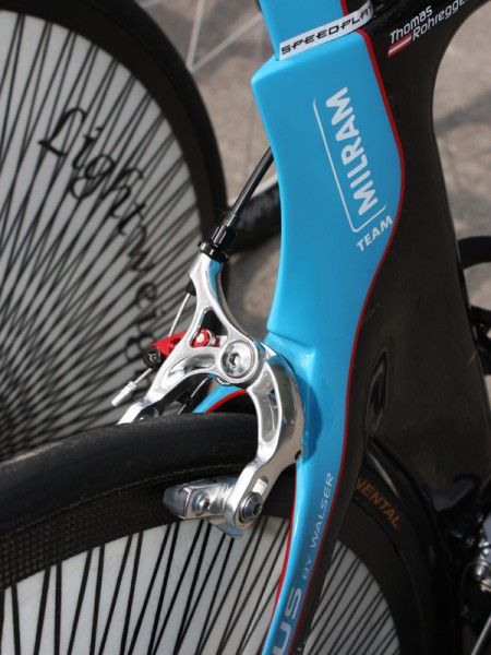 The team's aero frames are temporarily fitted with alternate brakes since the SRAM Red caliper's stiffening brace doesn't currently fit beneath the trailing edge of the seat stay wishbone. The team says future frames will be modified appropriately.