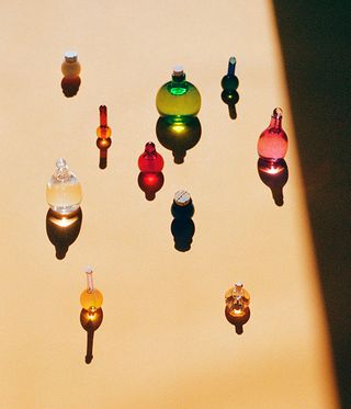 multiple multi-colour handblown glass bottles of skincare products by Kindred Black